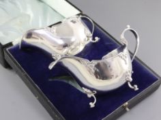 A cased pair of George V silver sauce boats, by Walker & Hall, hallmarked Sheffield 1930, of oval