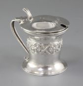 An Edwardian Arts & Crafts silver mustard pot, by Omar Ramsden & Alwyn Carr, hallmarked London 1903,