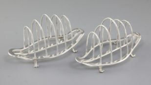 A matched pair of George V silver toast racks, by George Howson, hallmarked Sheffield 1922 and 1930,