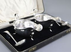 A cased pair of George V silver sauce boats and matching ladles, all hallmarked Sheffield 1933 and