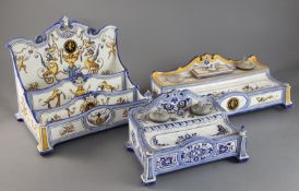 A Gien faience stationery rack, c.1890, with three stepped compartments painted with grotesques,