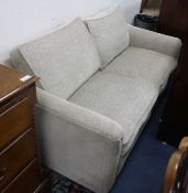 A two seater settee, upholstered in herringbone pattern beige fabric, W.6ft