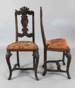 A pair of mid 18th century walnut chairs, probably Liege, with scroll carved top rails above