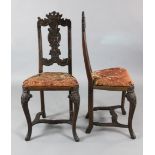 A pair of mid 18th century walnut chairs, probably Liege, with scroll carved top rails above