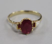 A 14ct and ruby ring with tapered cut diamond set shoulders, size L.