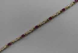 A 9ct gold, ruby and diamond line bracelet, 18cm.