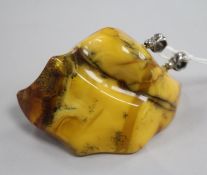 A raw amber pendant with two white metal bales, gross weight 58 grams, 78mm.
