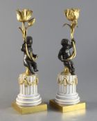 A pair of Louis XVI style bronze and ormolu candlesticks on fluted porcelain bases, 11in.https://