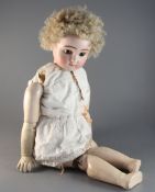 A late 19th century German bisque head doll with glass eyes, pierced ears and composition body,