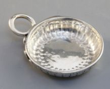 A French silver wine taster, 18th century, gadrooned and with snake handles, rim inscribed 'Estienne