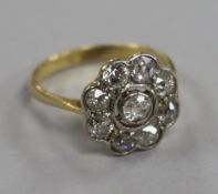 An 18ct gold and nine stone diamond cluster ring, size L.