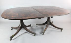 A George III mahogany twin pillar dining table, circa 1800, with D-shaped ends and two leaves, on