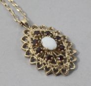 A modern 9ct gold, white opal and garnet pendant, on a 9ct gold chain, pendant 27mm.