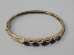 A boxed 9ct gold, sapphire and diamond hinged bangle.