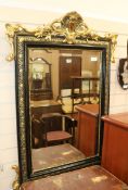 An ebonised and gilt wall mirror, W.85cm