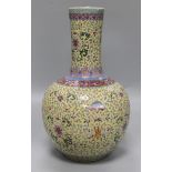 A Canton enamelled bottle vase, decorated flowers, foliate scrolls and Chinese characters on a