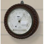 An Edwardian oak aneroid barometer W.28cm