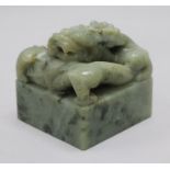 A Chinese green stone 'dragon' seal, the top carved in open work and high relief with a curling