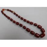 A single strand graduated simulated cherry amber barrel shaped bead necklace, gross weight 68 grams,