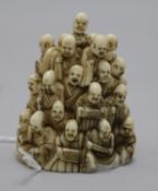 A Japanese ivory netsuke of multiple rakan, Meiji period, the underside carved as clouds inset