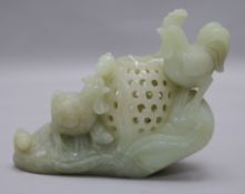 A Chinese celadon jade censer, carved as chickens and chicks beside a basket, on a rock work base,