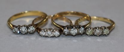Four 18ct gold and three stone diamond rings.