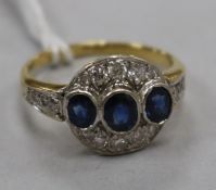 A yellow metal sapphire and diamond cluster dress ring, with diamond set shoulders, size O.