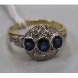 A yellow metal sapphire and diamond cluster dress ring, with diamond set shoulders, size O.