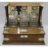 An Edwardian oak three bottle tantalus