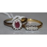 A ruby and diamond 9ct gold cluster ring and an 18ct gold and three-stone diamond ring.