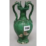 A Chinese green glazed pottery twin handled vase, in Tang style, with dragon head handles and a