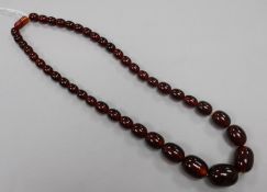 A single strand simulated cherry amber bead necklace, gross 75 grams, 58cm.