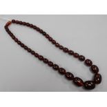 A single strand simulated cherry amber bead necklace, gross 75 grams, 58cm.