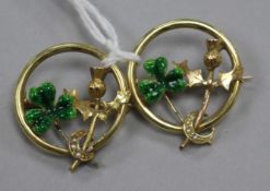 A pair of yellow metal, enamel and seed pear set shamrock and thistle openwork circular brooches,