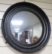 A circular ebonised wall mirror W.59cm