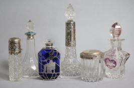Four assorted mounted scent bottles, a ruby flash glass scent bottle and a silver topped toilet