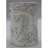 A Chinese biscuit porcelain brush pot, seal mark 'Wang Binrong', modelled in relief with a tiger