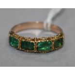 A yellow metal and four stone emerald half hoop ring (one stone replaced?), size N.