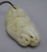 A Chinese white jade carving of a boy clambering on a finger citron, carved in relief with leaves, a