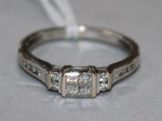 A modern 18ct white gold and Princess cut diamond set dress ring, with diamond set shoulders, size