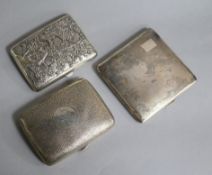 Two silver cigarette cases and a Chinese white metal cigarette case decorated with dragons and