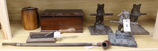 Three carved wood bear pipe racks, a 19th century tobacco cutter, a silver-mounted long pipe and