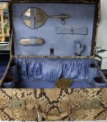 A 1930's python skin vanity case containing two silver mounted brushes, a mirror and a comb, case