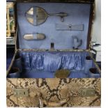 A 1930's python skin vanity case containing two silver mounted brushes, a mirror and a comb, case