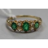 A 15ct gold, emerald and diamond seven stone ring, size O.