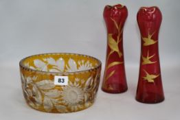 A pair of Philip Webb style parcel gilt cranberry glass vases, decorated with songbirds, and an