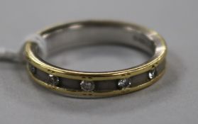 A modern 18ct two colour gold and five stone channel set diamond ring, size R.