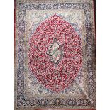 An Isfahan red and ivory ground carpet, with central medallion in a field of scrolling foliage and