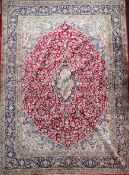 An Isfahan red and ivory ground carpet, with central medallion in a field of scrolling foliage and