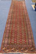 A Bokhara design red ground runner 340 x 97cm